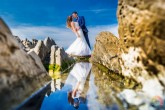Novios reflejados en el Agua entre dos rocas