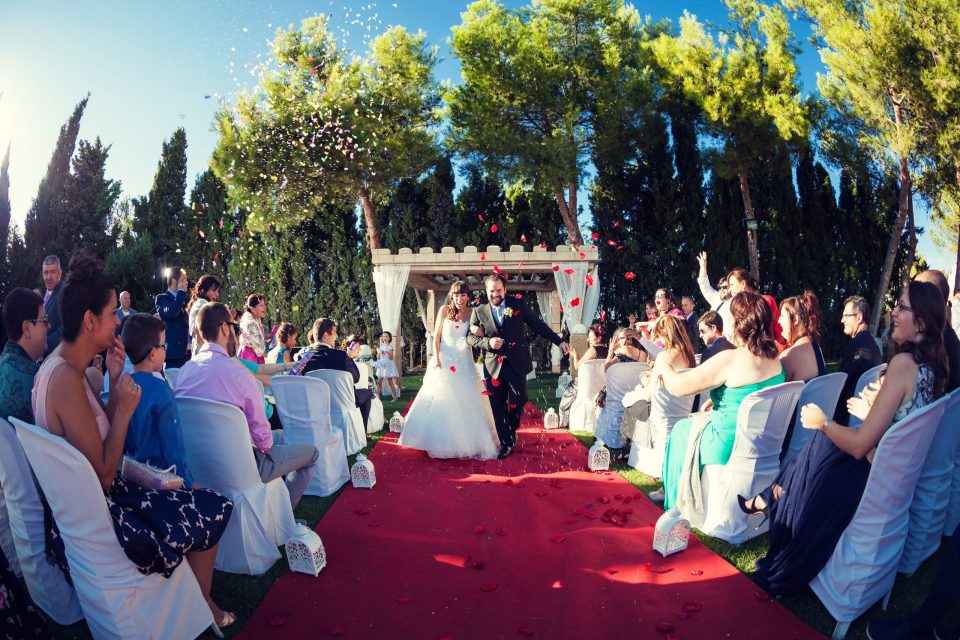 Ceremonia de boda al aire libre en una finca ajardinada.