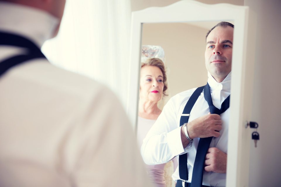 Durante los preparativos de una boda en una casa, un hombre vestido con camisa blanca.