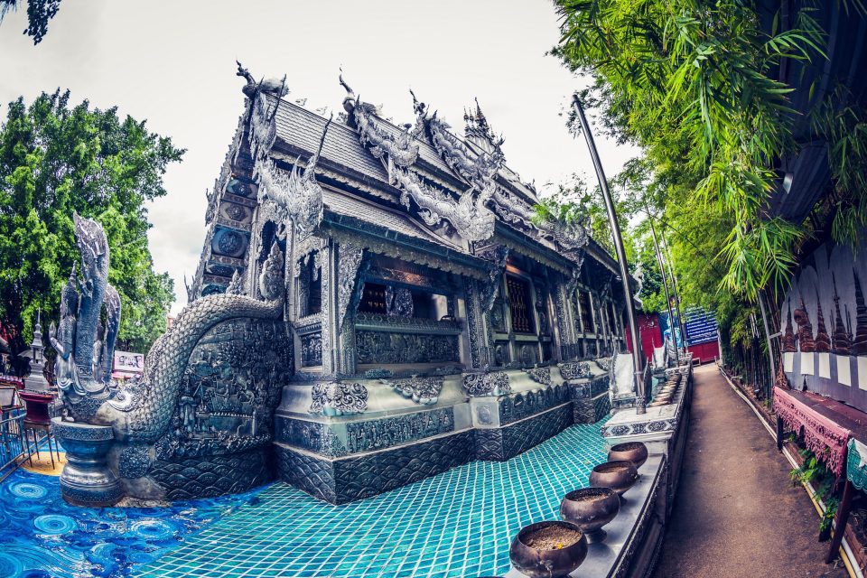 An ornate architectural building features elaborate carvings in silver tones.