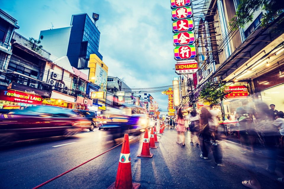 An urban scene at dusk on a commercial street, with buildings of varying heights.