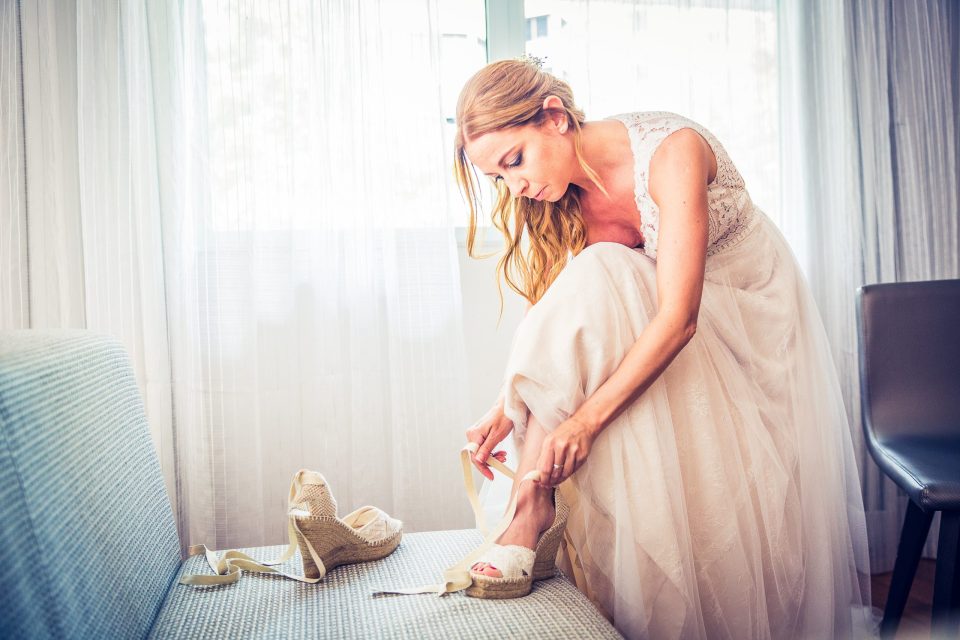 Fotografía de preparativos de boda en una habitación de hotel iluminada con luz natural.