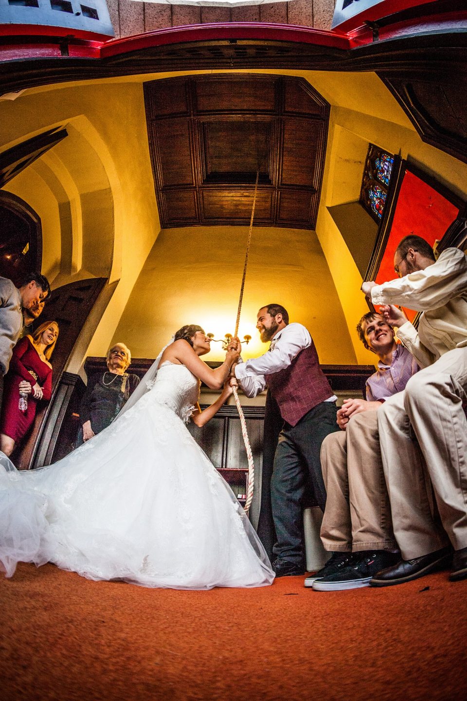 A wedding ceremony is photographed inside a church from a very low angle.