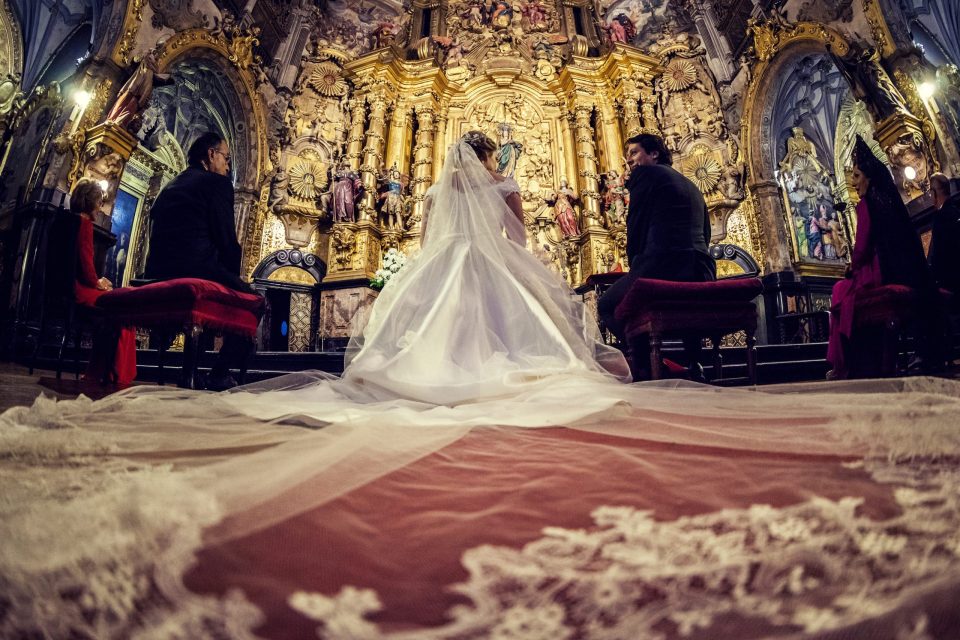 Fotografía de una ceremonia de boda en el interior de una iglesia ornamentada.