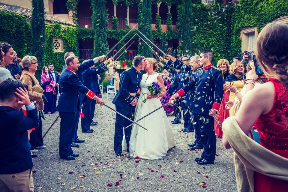 Fotografía de una ceremonia de boda en el patio ajardinado de una finca.