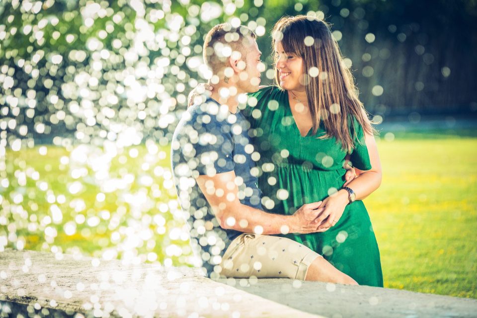 Fotografía de una pareja abrazada y sonriente en un parque.