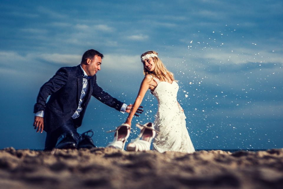 Fotografía de una pareja vestida para una boda en la playa.