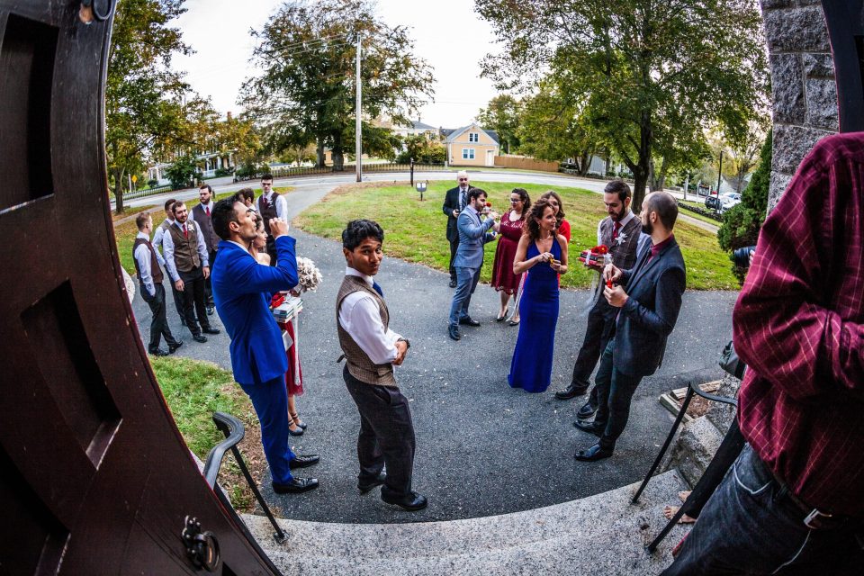 A group of elegantly dressed people gathered outside a building entrance.