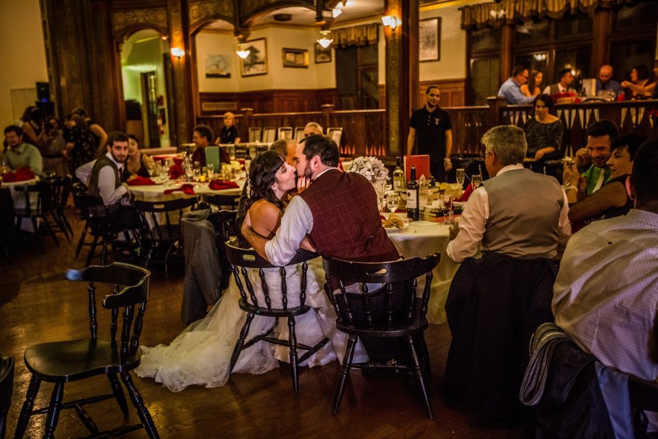 The interior of a classic-style restaurant or dining room has several tables occupied by diners.