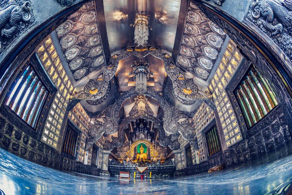 An ornate temple interior is viewed in symmetrical perspective.