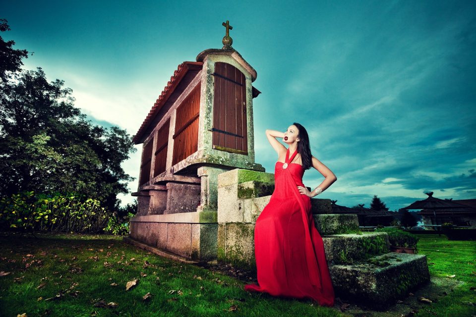 La Coruña - Hórreo. Fotografía exterior de un hórreo tradicional de piedra y madera, rematado con una cruz.