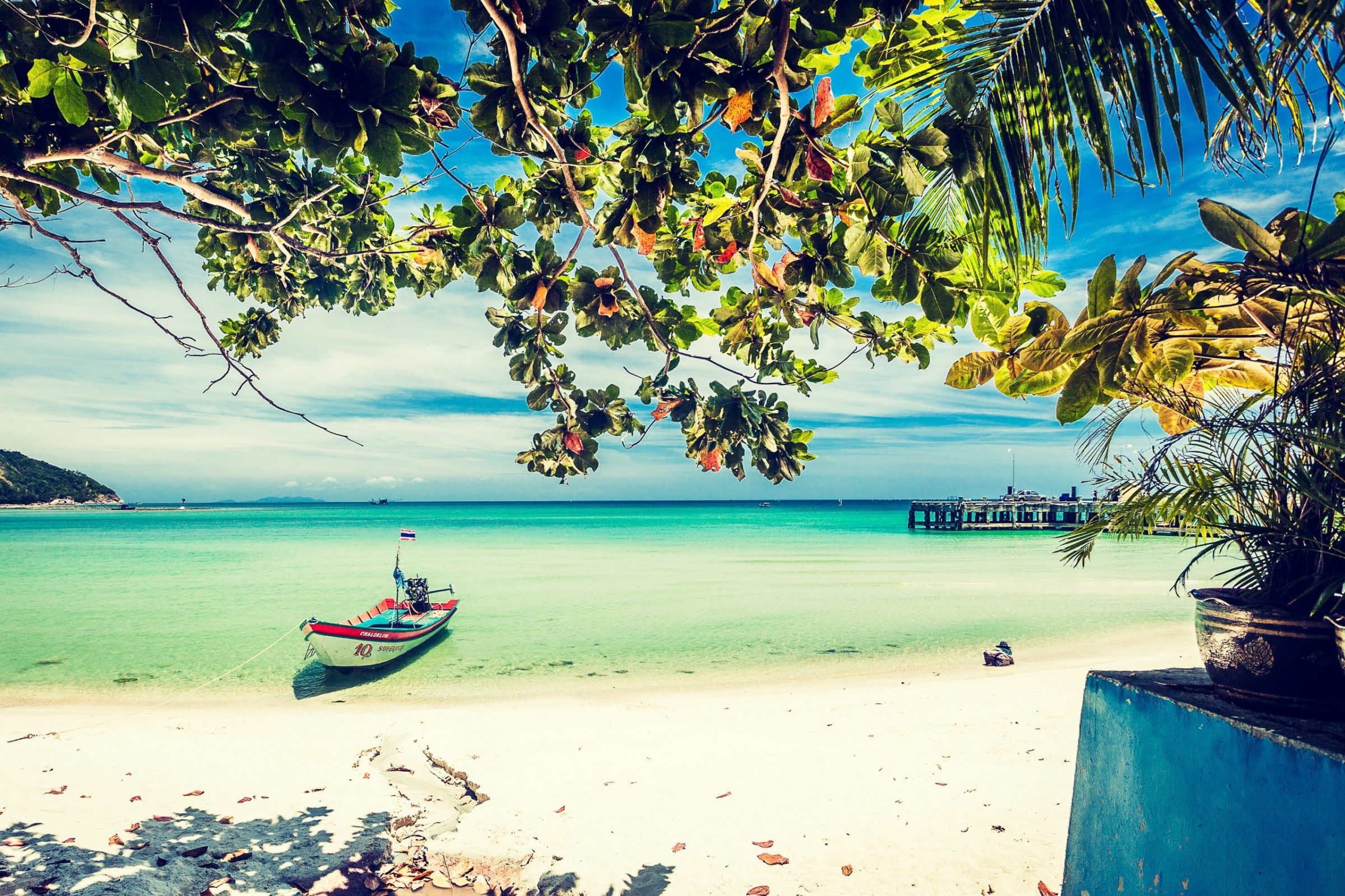 Tropical beach landscape with white sand and calm turquoise waters.