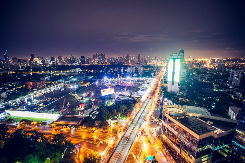 This is a night-time panorama of a densely urbanised city with numerous illuminated buildings.