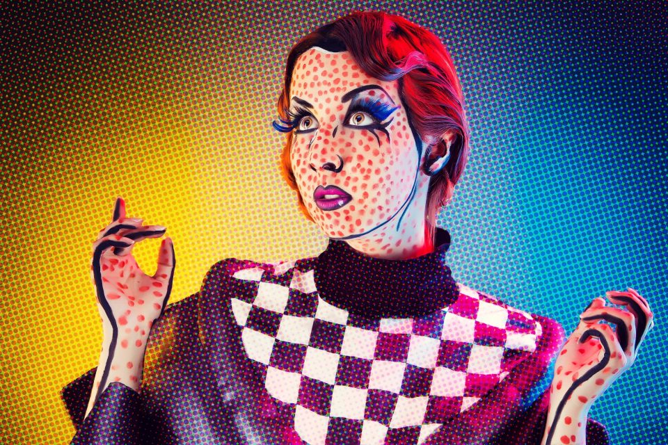 Retrato editorial de una modelo con cabello rojo y maquillaje artístico de inspiración pop.