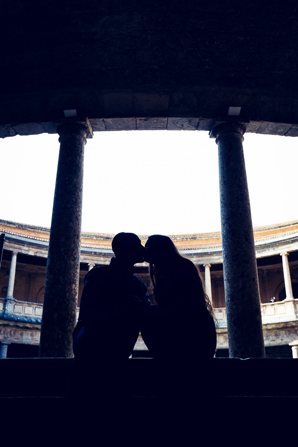 Silhouette of two people sitting very close together, apparently a couple.