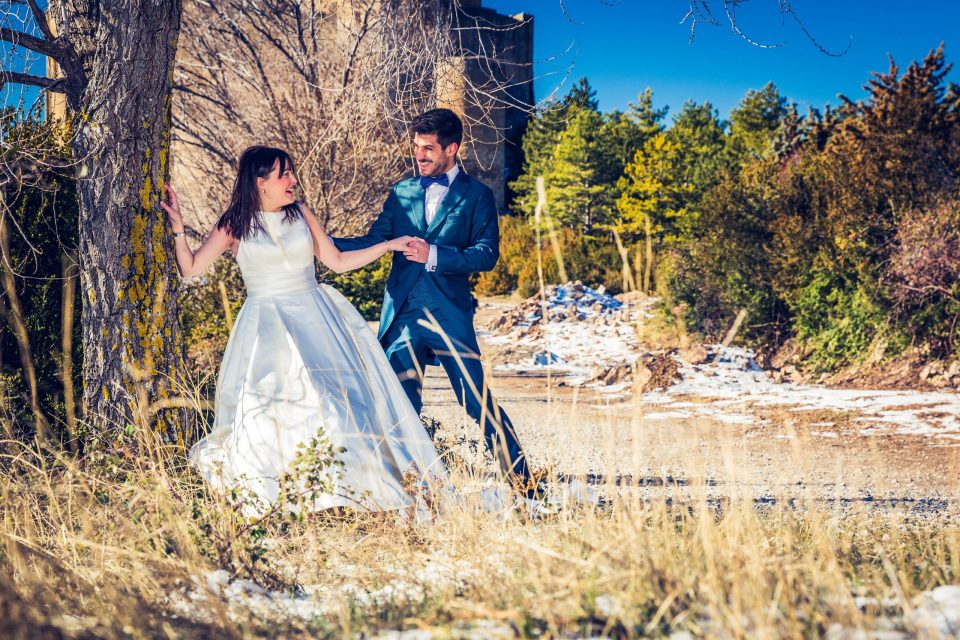 A couple, she in a white dress and he in a blue suit.