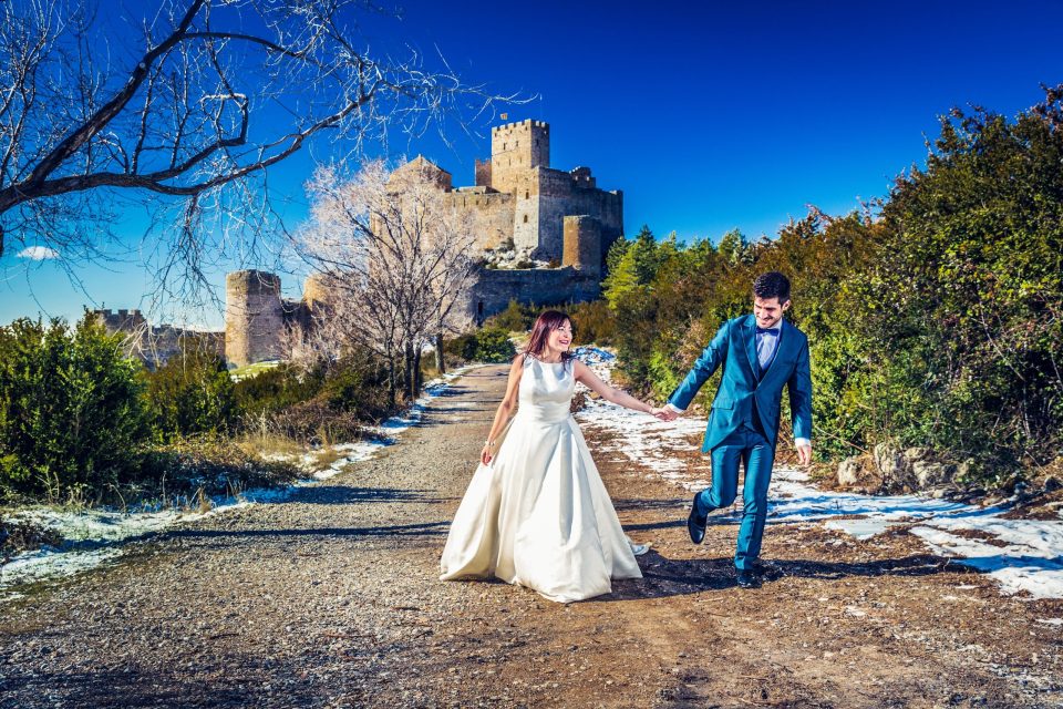A couple dressed for a wedding walks hand in hand along an outdoor path.