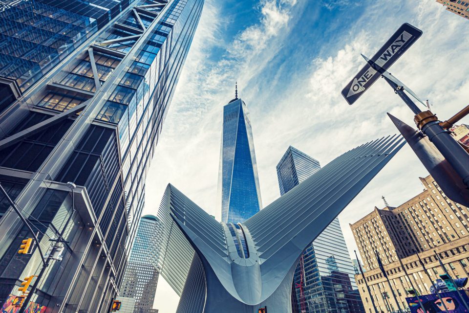 Low-angle view of an urban area with several tall glass and steel buildings.