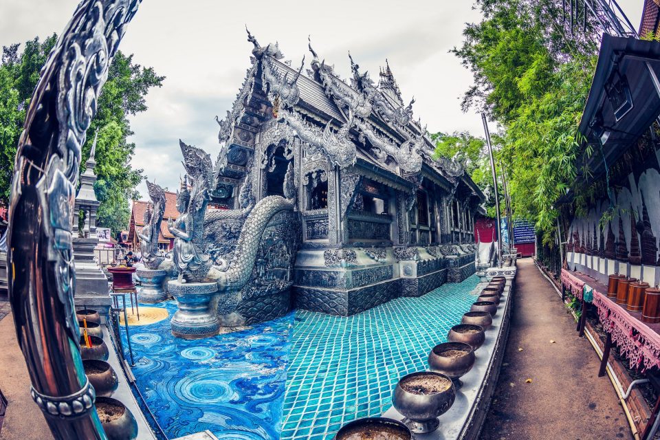 An ornately designed temple has richly decorated façades and roofs in silver tones.