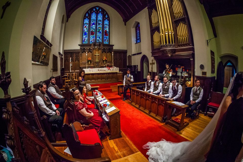 A panoramic view of the interior of a church during a wedding ceremony.