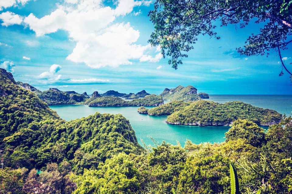 A panoramic view from an elevated area overlooks an archipelago of vegetation-covered mountainous islands.